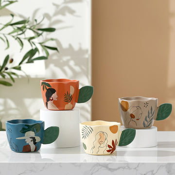 Handbemalte Keramiktasse mit geformtem Blattgriff und künstlerischem Gesichtsmotiv