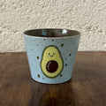 Handmade ceramic mug with cute avocado design, speckled light blue glaze, perfect for coffee or tea