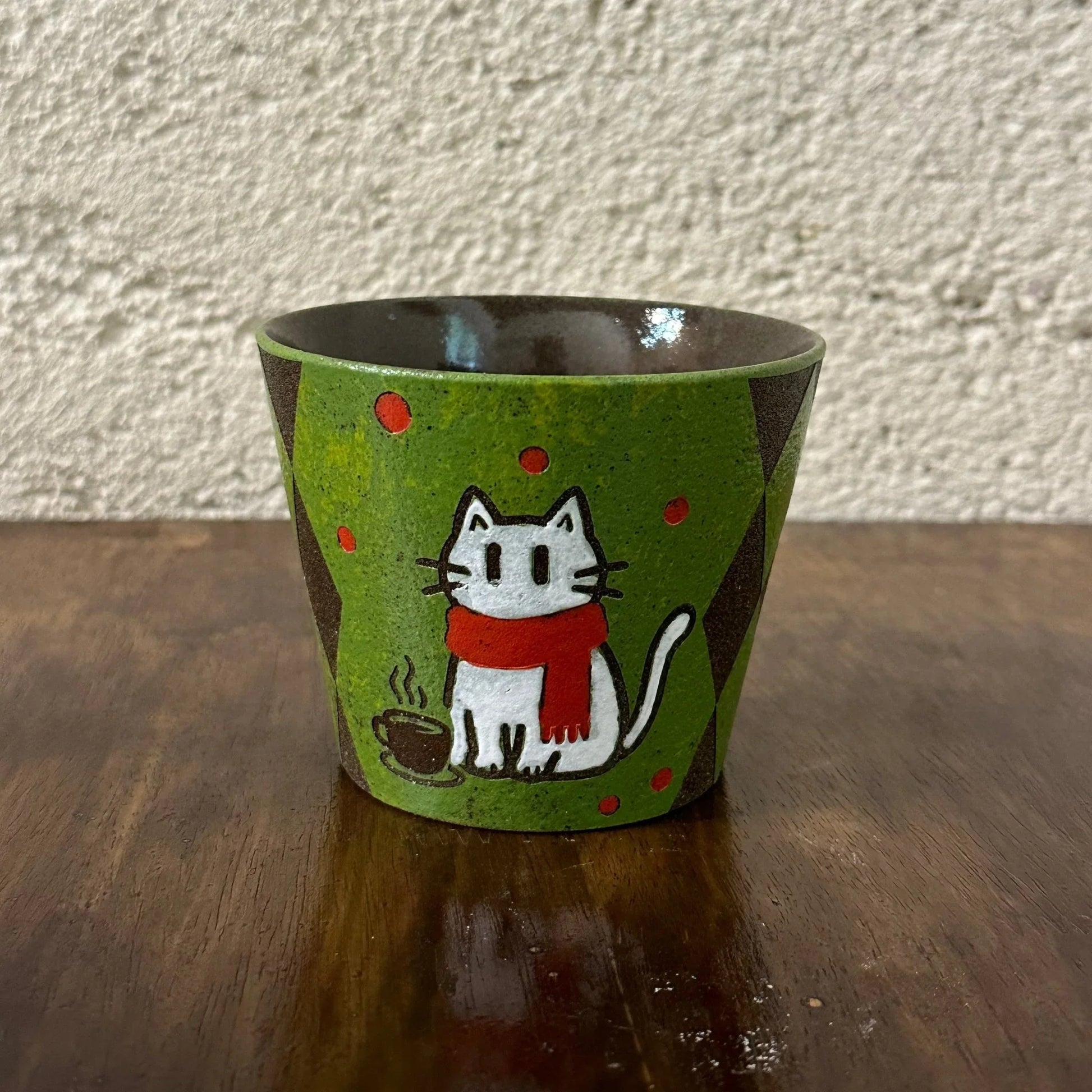 Handmade ceramic mug with cute white cat in red scarf, green speckled glaze, and coffee cup design